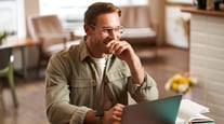 image-young-digital-nomad-man-glasses-sits-cafe-works-from-coffee-shop-uses-laptop-coworking-space-wears-glasses-drinks-his-beverage